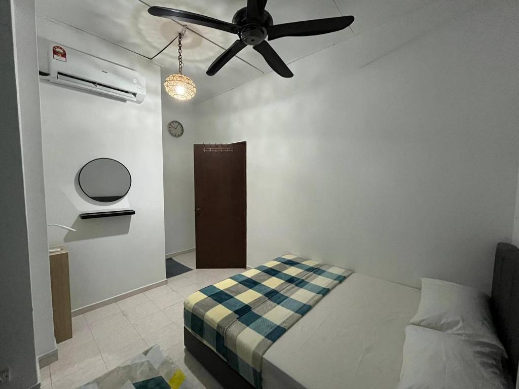 a bedroom with a bed and a ceiling fan at Sweet Roses Homestay- Free WiFi, Nearby UiTM in Bandar Puncak Alam