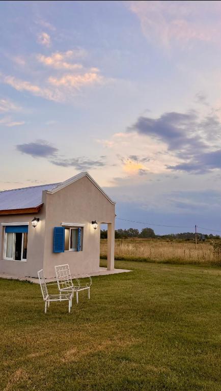a white house with a bench in a field at Quinta La Carlota in Navarro