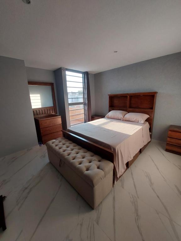 a bedroom with a bed and a couch in it at Casa De La Suerte in Chapulco
