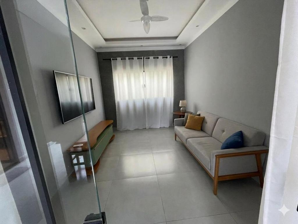 a living room with a couch and a window at Casa de lazer privativa in Barretos