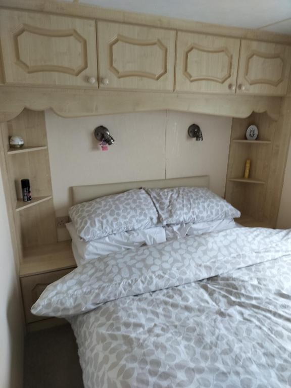a bedroom with a bed with a white comforter at Skegness Ingoldmells near Skegness raceway holiday let by Sophia in Ingoldmells