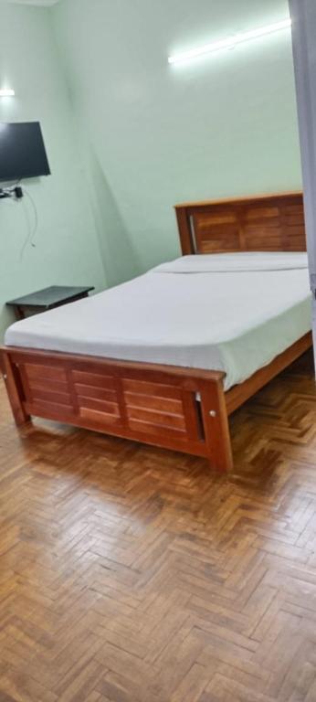 a bed with a white mattress on a wooden floor at Ooty Peak view villa in Ooty
