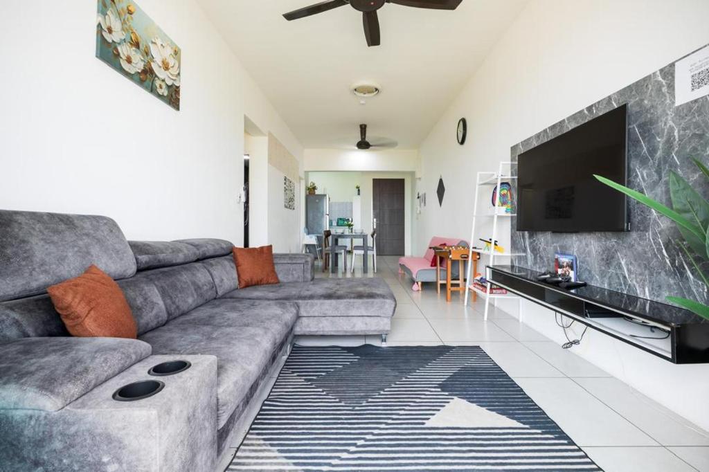 a living room with a couch and a flat screen tv at Meritus Suites - 8pax in Perai