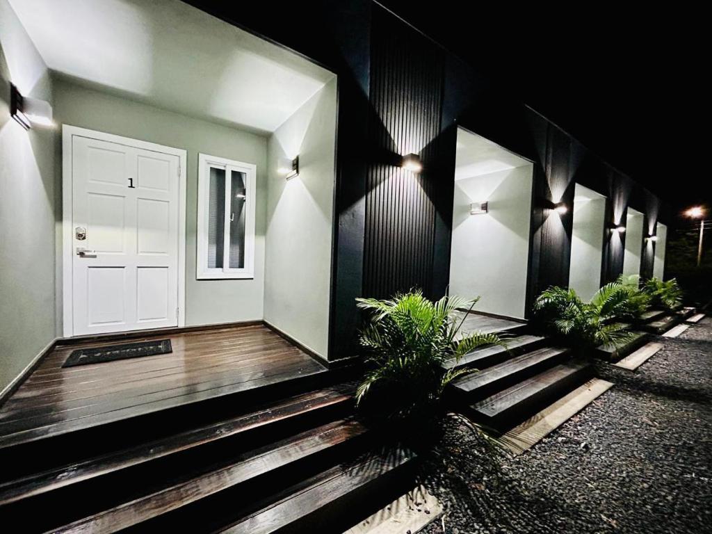 a house with a white door and some plants at Apartaments in Sandy Bay in Sandy Bay