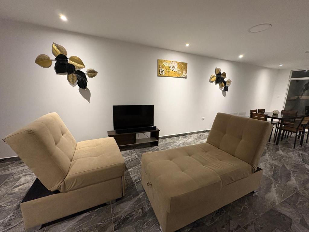 a living room with two chairs and a television at Alma del Mar in Volcán Chimborazo