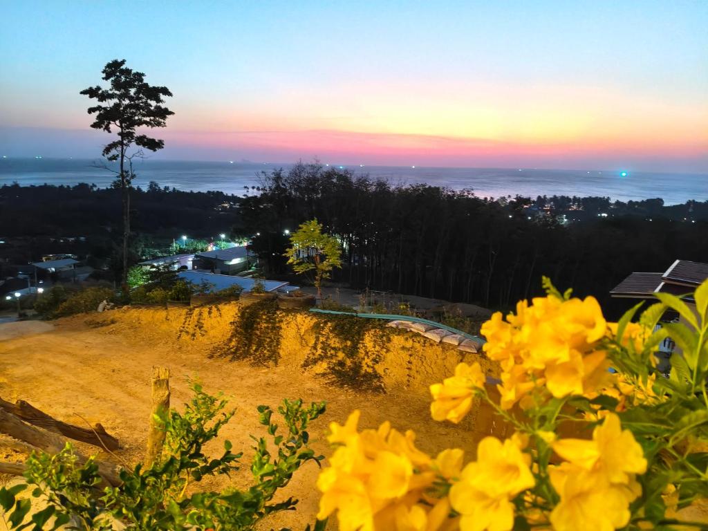a view of a hill with yellow flowers at Laeley 1,000 miles resort in Ko Lanta Yai