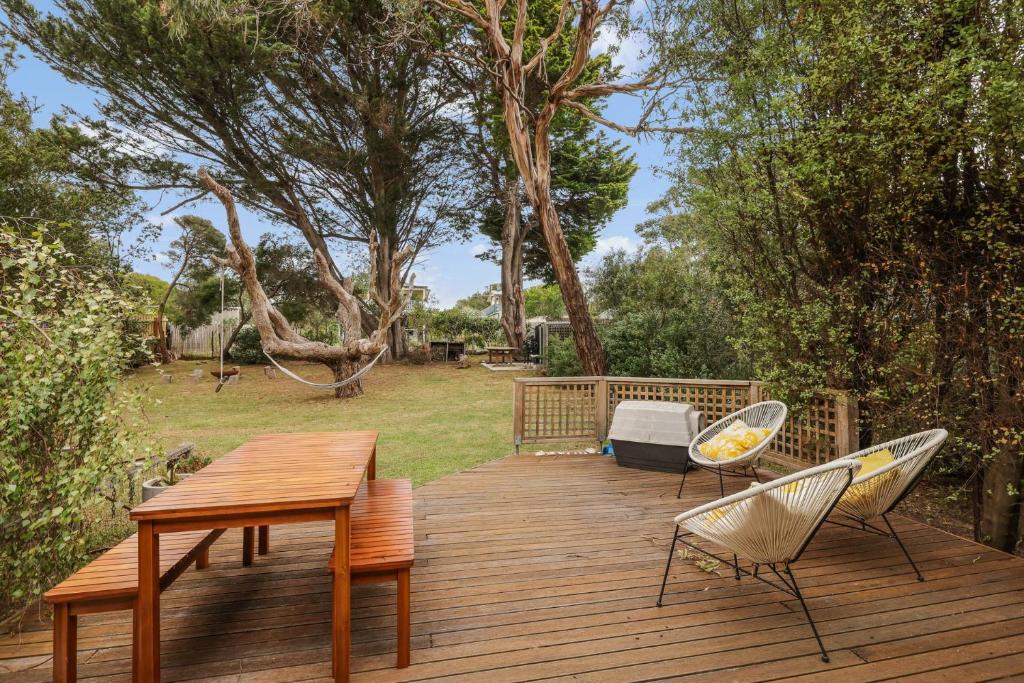 a wooden deck with a table and two chairs at The Bach at Ventnor in Ventnor