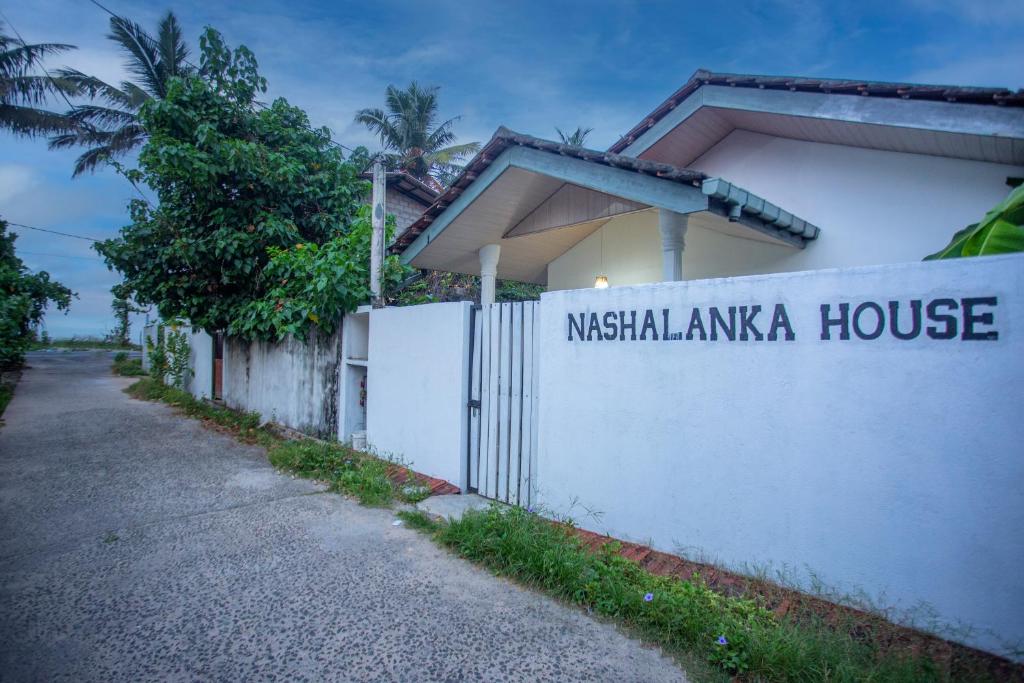 a white fence with the name of a nicaragua house at Nasha Lanka House in Koggala