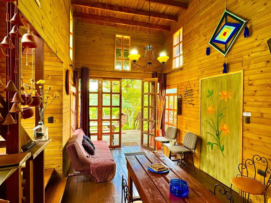 a living room of a wooden cabin with a couch and a table at Cabañas ecológicas Xuetama in Villa de Leyva