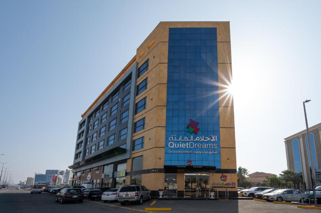 a building with the sun shining on the side of it at Quiet Dreams - Serviced Apartments King abdul Aziz Street Branch in Jeddah