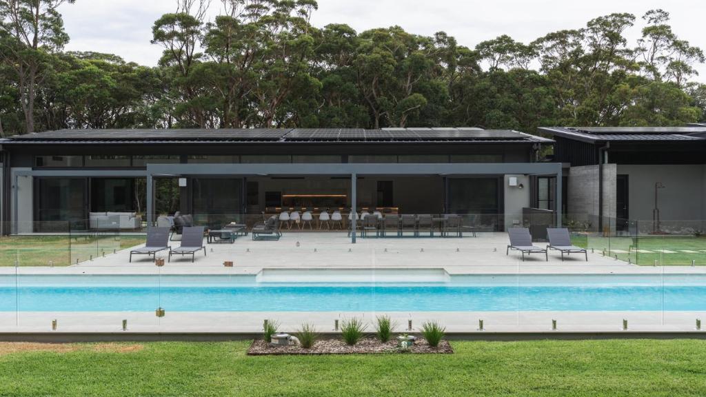 a house with a swimming pool in front of it at Launa Killcare Heights in Killcare