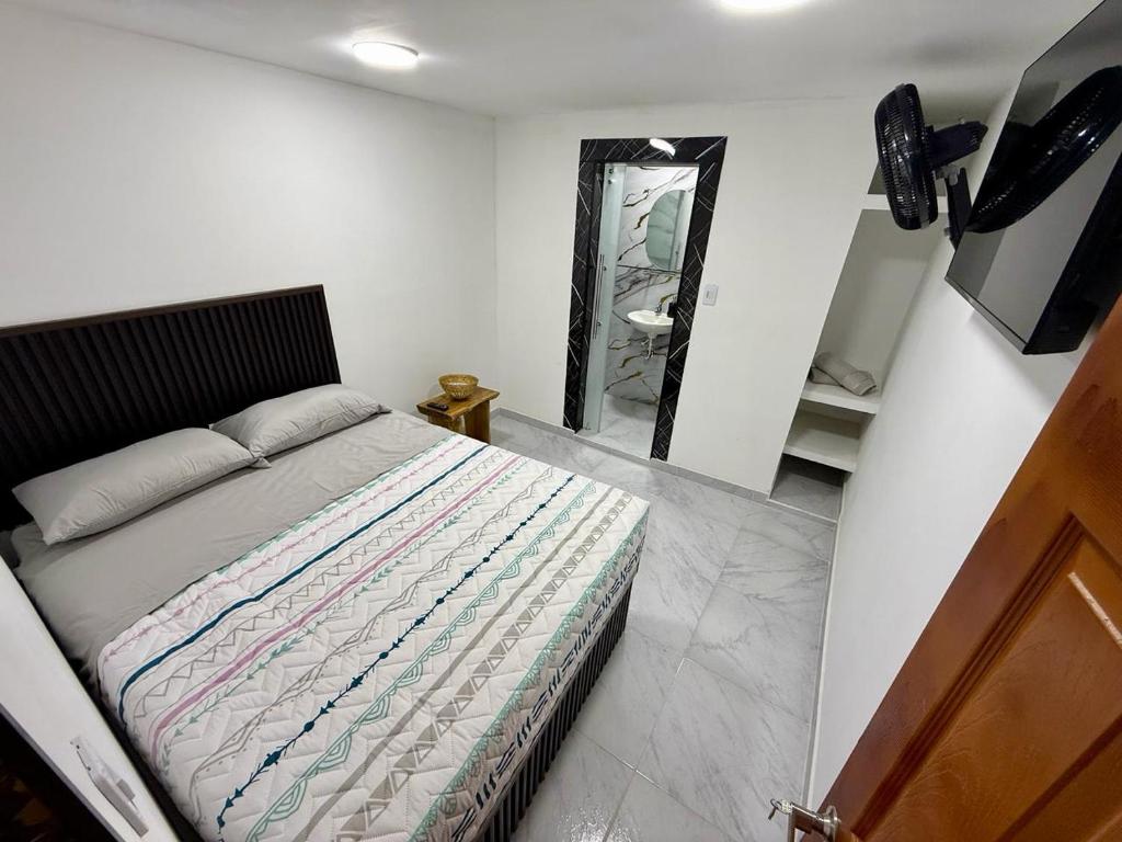 a bedroom with a bed and a mirror at Posada Del Puerto in Armenia