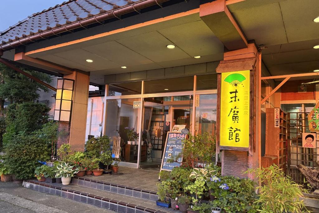 ein Laden mit einem gelben Schild an der Vorderseite in der Unterkunft Suehirokan in Tagami