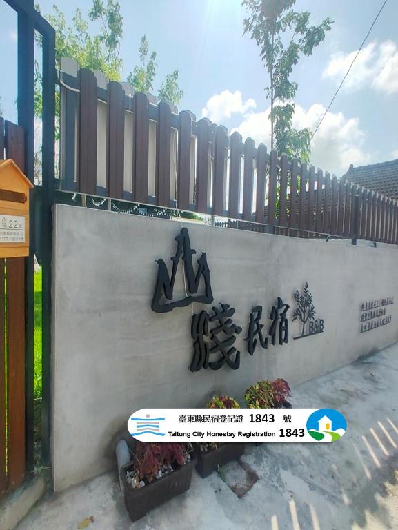 a wall with a sign on it next to a fence at 山淺民宿 Yamasaki Old House in T'ai-pin-ts'un