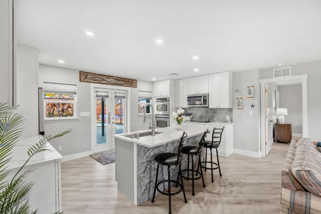 a kitchen with white cabinets and bar stools at 882 Cody Avenue in Sebastian