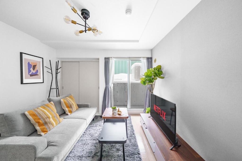 ein Wohnzimmer mit Sofa und Fernseher in der Unterkunft RT2 103 rk in Sapporo