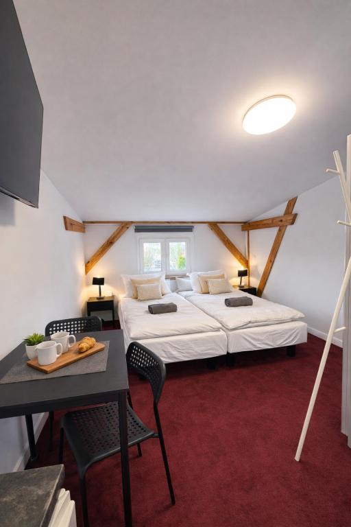 a bedroom with a bed and a table with chairs at Apartamenty Stary Młyn in Wronki