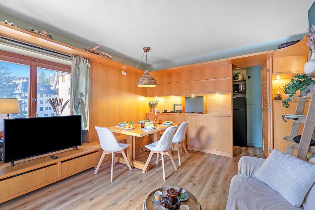 a living room with a television and a table and chairs at Appartamento Alpine Suite - Happy Rentals in Sestriere