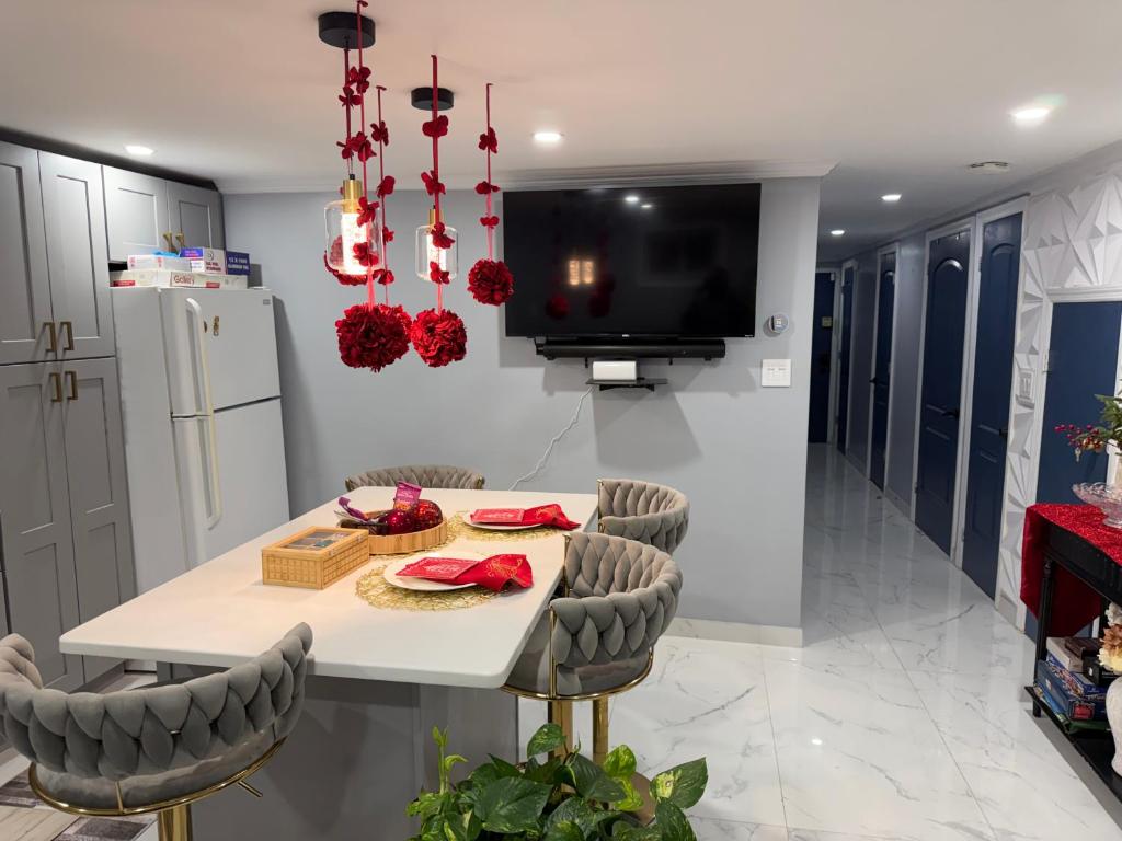 a kitchen with a white table and chairs and a tv at Private Paradise bk in Brooklyn