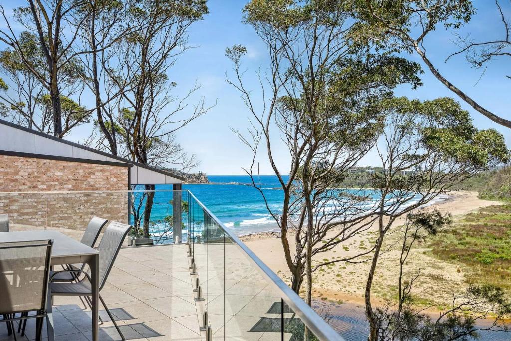 a view of the beach from the balcony of a house at Architectural Beachfront Escape Yowani House in Tomakin