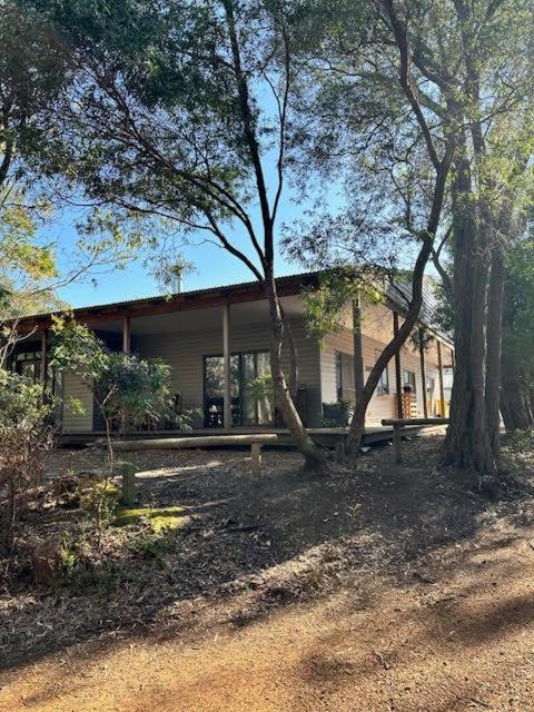 a house with trees in front of it at Coalmine Beach Holiday Park in Walpole