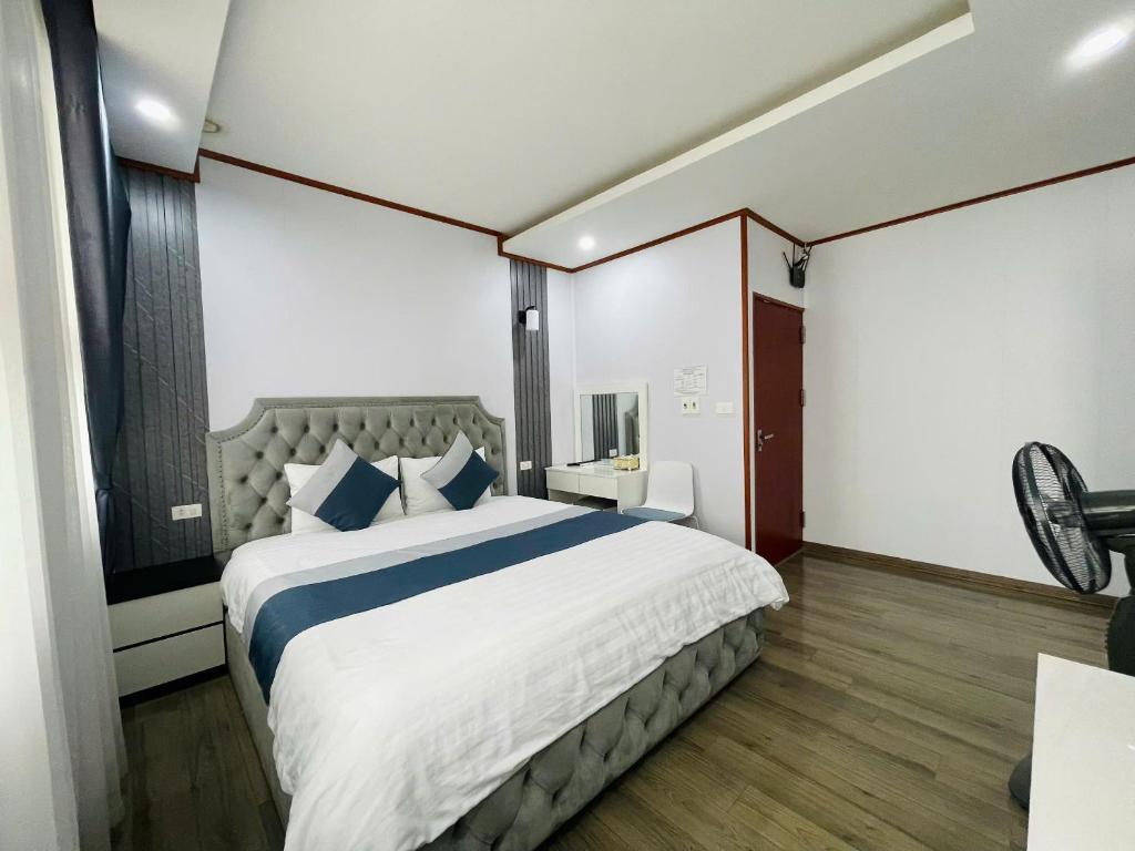 a bedroom with a large white bed with blue pillows at Home Villa TP Giao Lưu in Hanoi