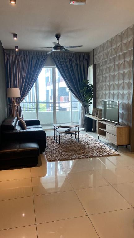 a living room with a couch and a tv at The Osborne Apartments in Ipoh