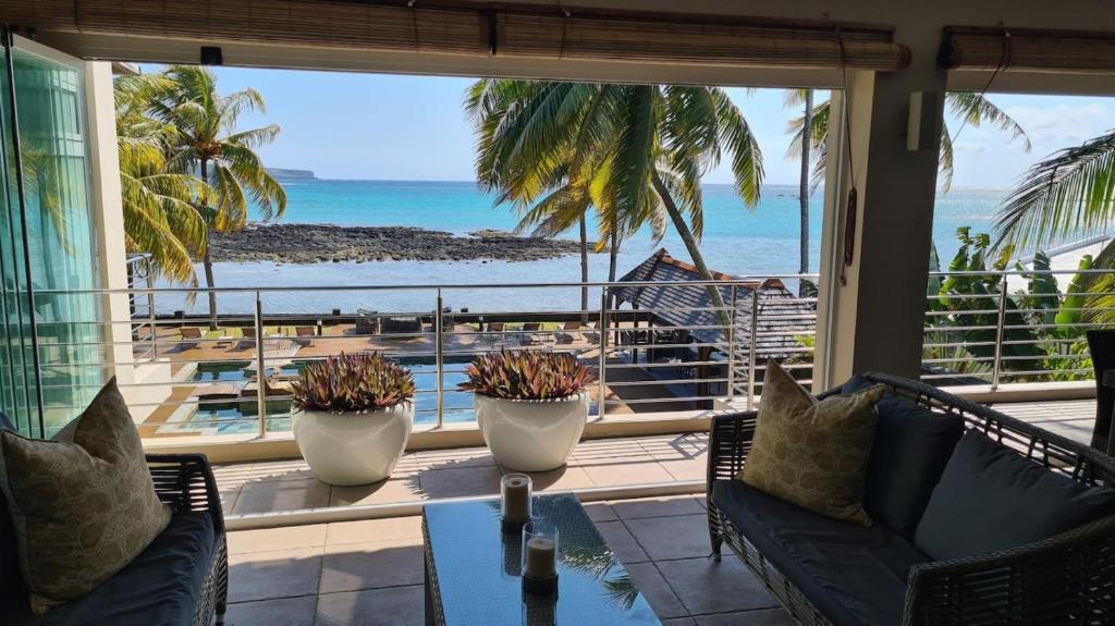 a living room with a view of the ocean at Luxury 3BR Direct Beach Access & Pool in Cap Malheureux