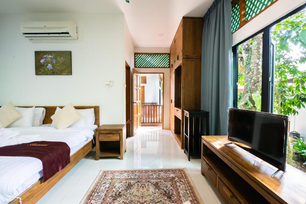 a bedroom with a bed and a flat screen tv at Bidaisari Resort in Kampong Sum Sum