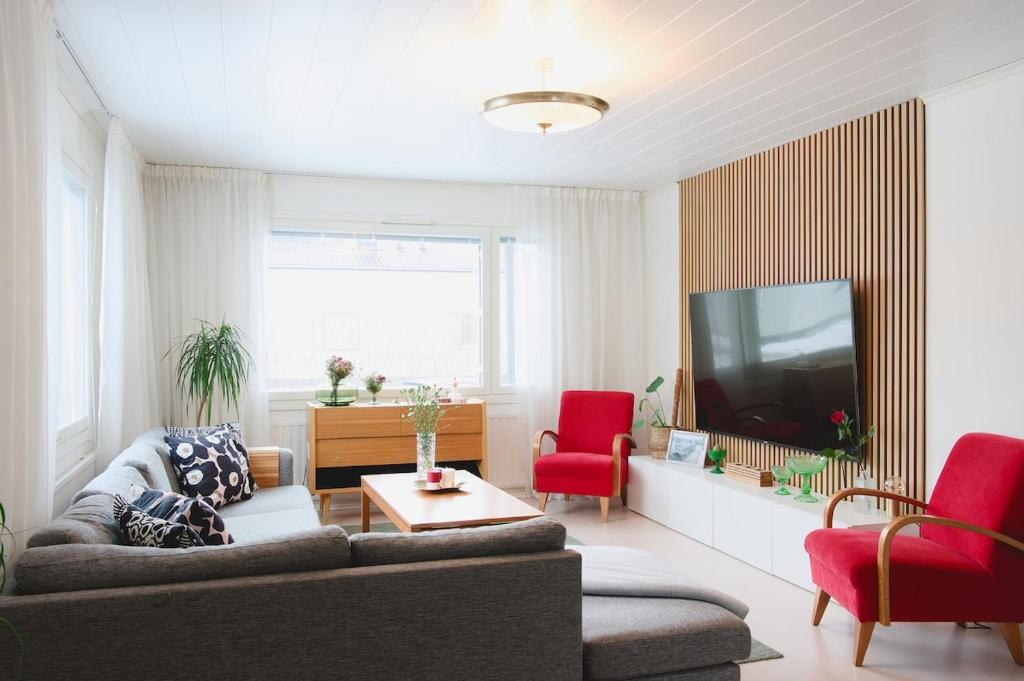 a living room with a couch and a tv at Villa Rimppari täydellinen porukalle 9 hlö puusauna nuotiopaikka ja parkki in Oulu