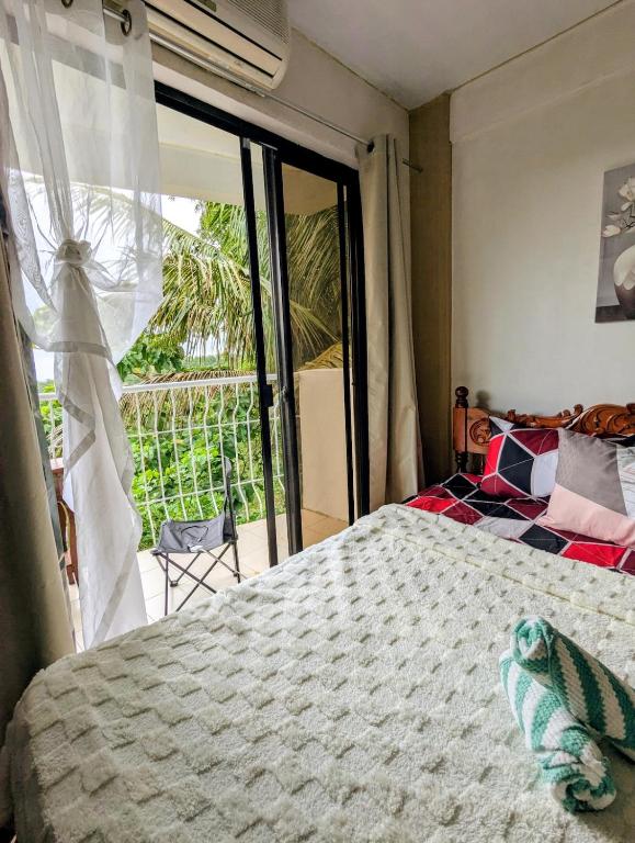 a bedroom with a bed and a sliding glass door at Tagaytay Resthouse 3 big rooms in Ulot