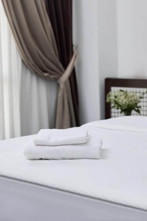 two white towels are sitting on top of a bed at Чынар Отель in Änew