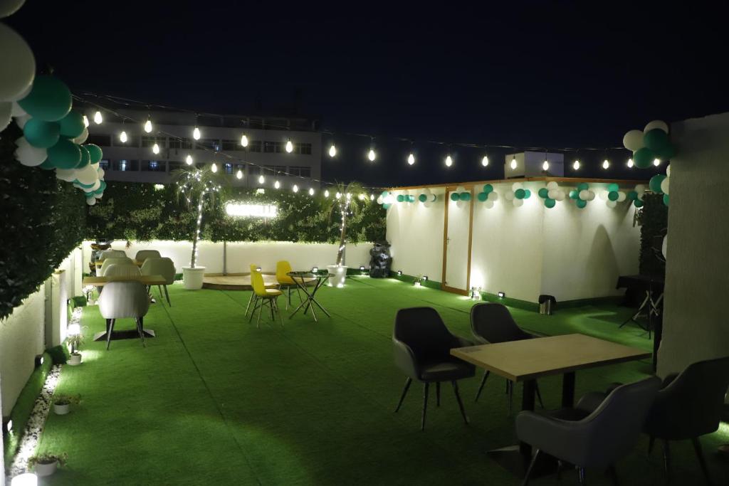 a patio at night with chairs and tables and lights at Grenelle-Indirapuram in Ghaziabad