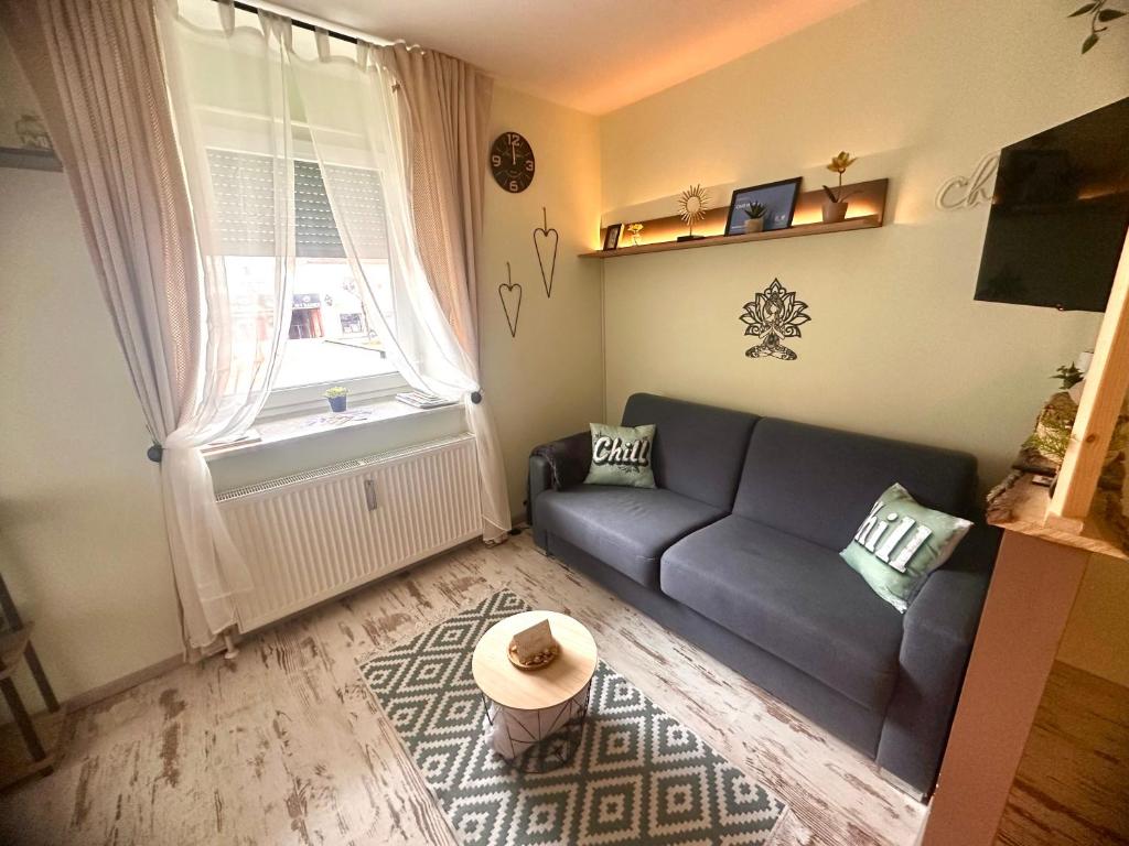 ein Wohnzimmer mit Sofa und Fenster in der Unterkunft Chill Home in Klagenfurt am Wörthersee