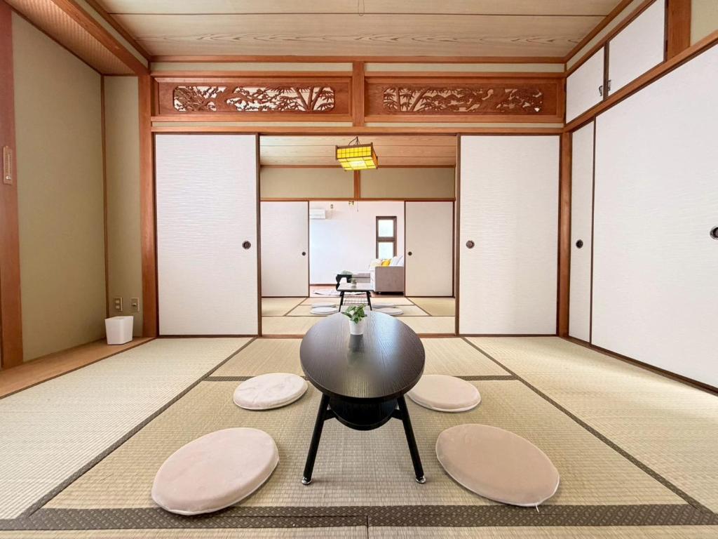 ein Zimmer mit einem Tisch und Stühlen in der Unterkunft ura tsumo in Kasaoka