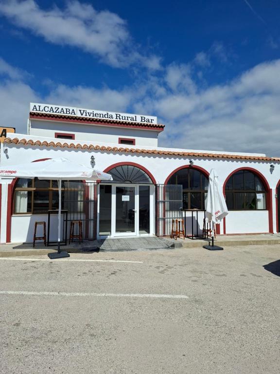 a white building with a sign on top of it at Vivienda Rural Alcazaba in Chipiona