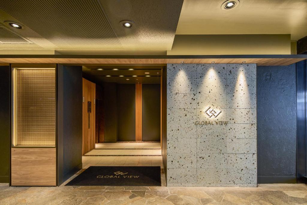 a lobby of a luxury hotel with a stone wall at Hotel Global View Urawa in Saitama