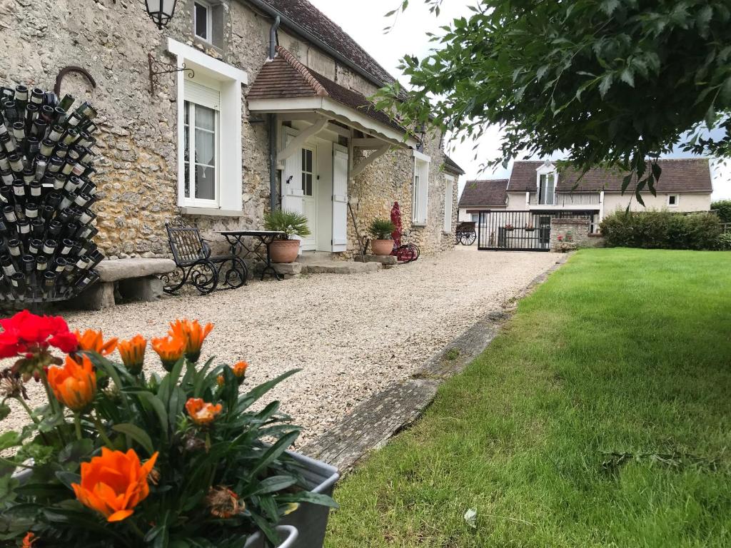a house with orange flowers in front of a yard at Relais du Chat Prosper in Lescherolles