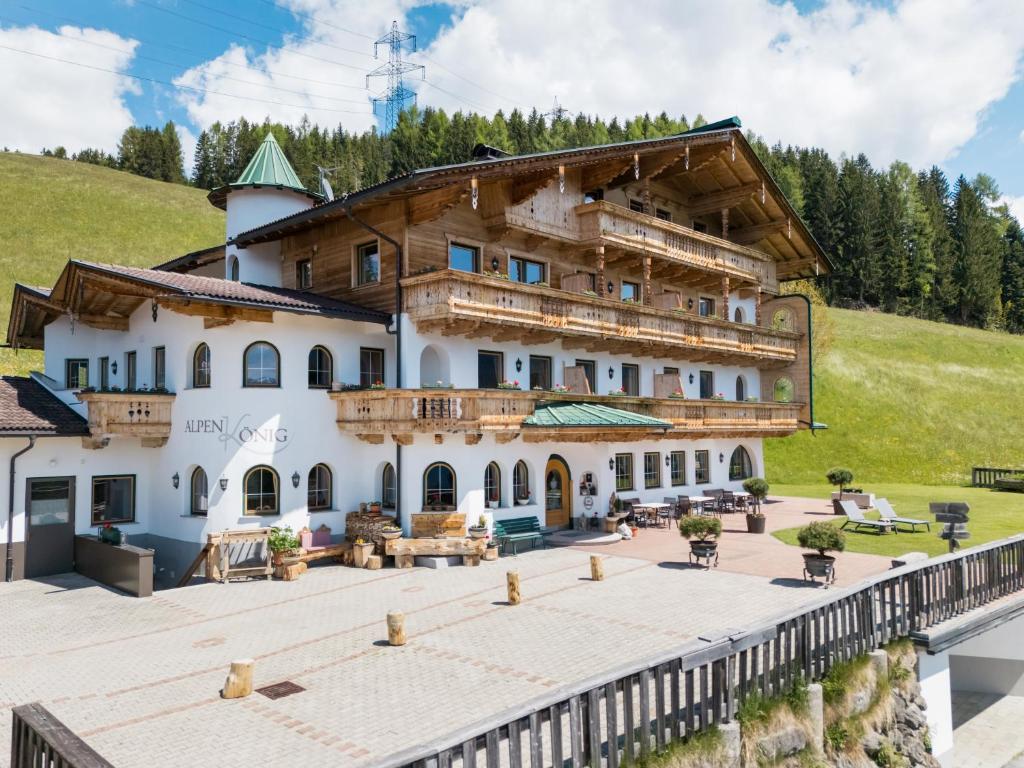 a large building on a hill with a wooden deck at Alpenkönig in Zell am Ziller