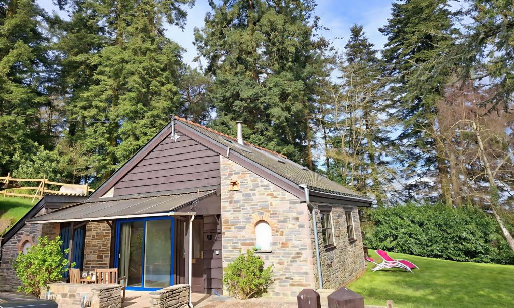 a tiny house in a yard with trees at Cottage Les Séquoias de l'Oust Clim mobile in Malestroit