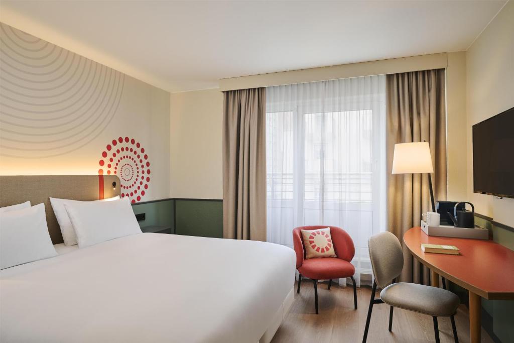 a hotel room with a bed and a desk at iStay by NH Berlin City Ost Hotel in Berlin