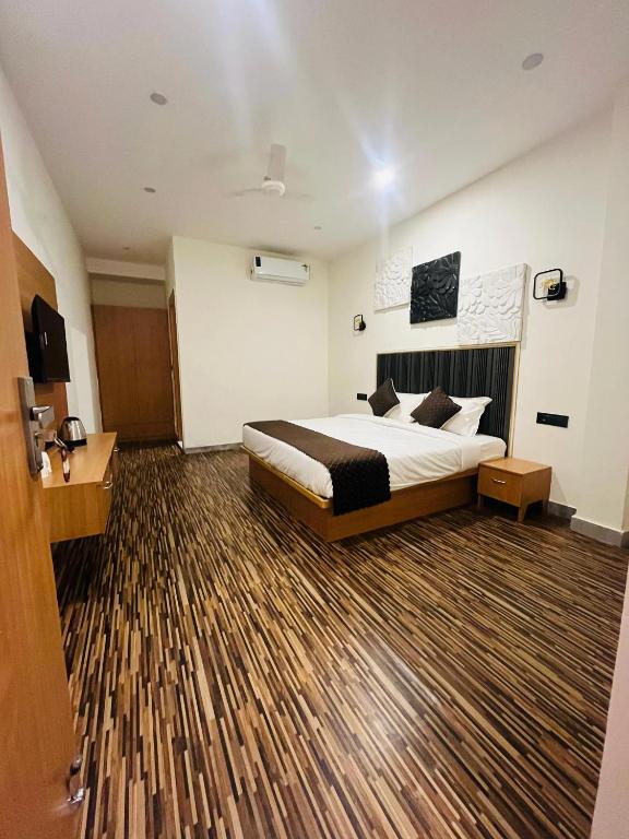 a hotel room with a bed and a wooden floor at hotelindriya in Noida