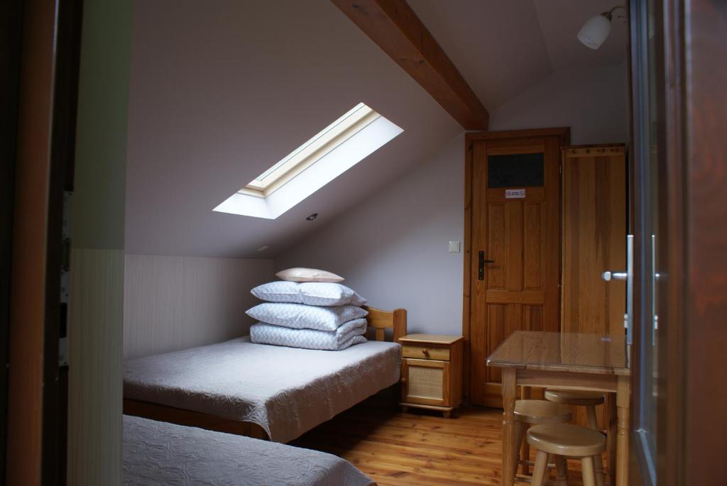 a attic room with a bed and a skylight at Dom w Kwiatach in Ojców
