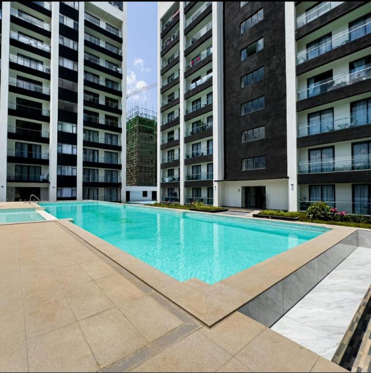 a swimming pool in front of two tall buildings at Ideal homes in Gatunga