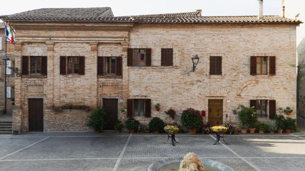 a brick building with a fountain in front of it at Casa Montefiori in Montefiore dellʼAso