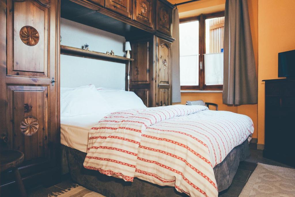 a bedroom with a large bed with a wooden frame at B&B del Villaggio in Argentera