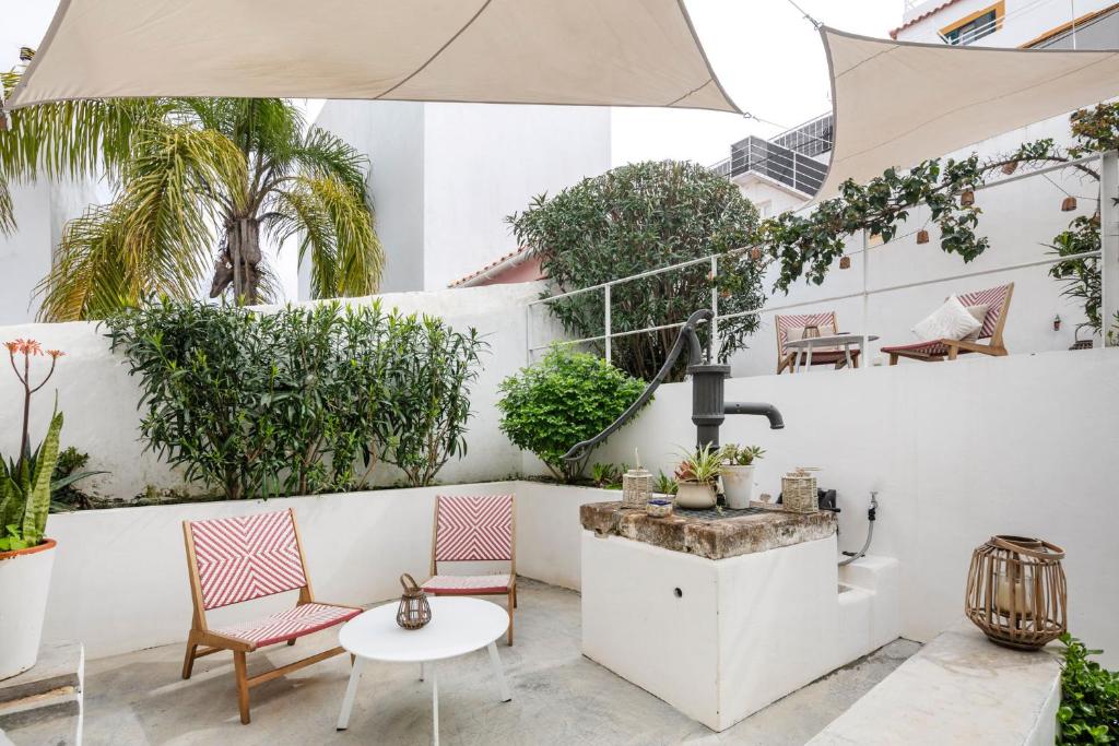 an outdoor patio with chairs and a fountain at Alma da Vida Ferragudo in Ferragudo