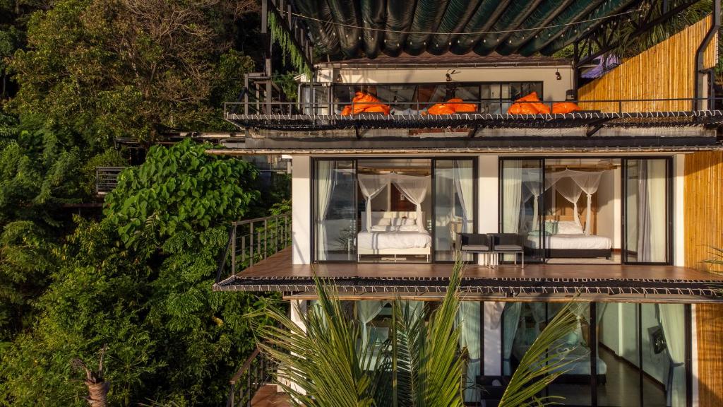 a building with a balcony with two beds at The Cozy Beachfront Phuket in Patong Beach