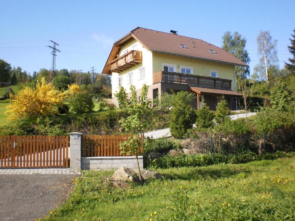 a house with a fence in front of a yard at Apartman Kublovi in Vimperk