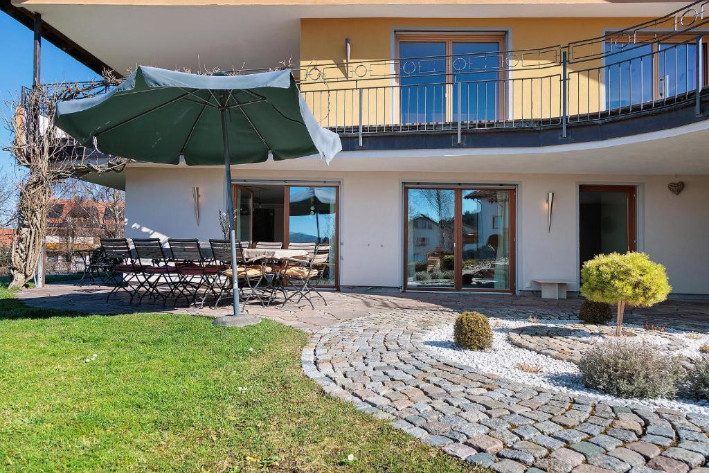 a patio with an umbrella in front of a house at Freiraum in Weiler-Simmerberg